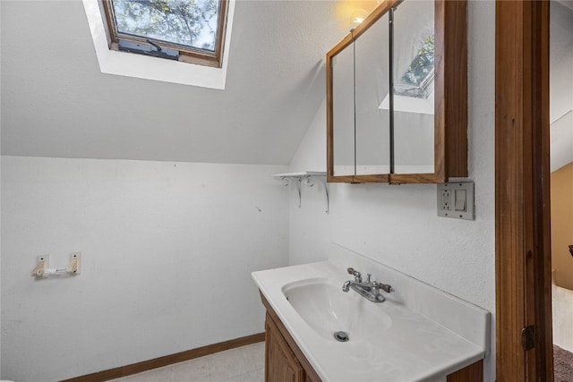 bathroom featuring vanity and vaulted ceiling with skylight