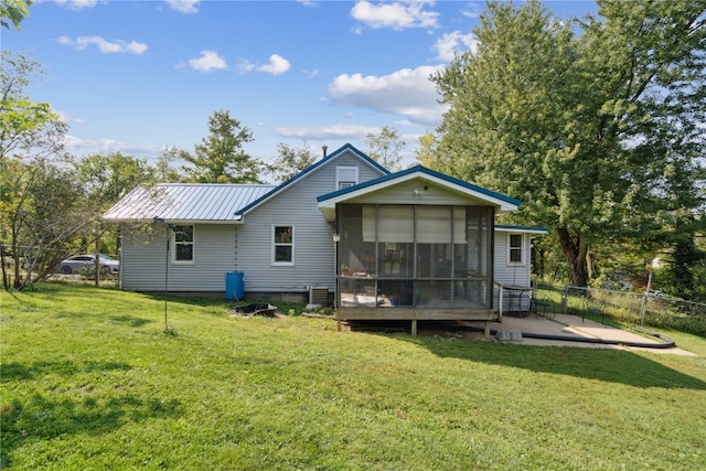 back of house with a patio, a lawn, and a sunroom