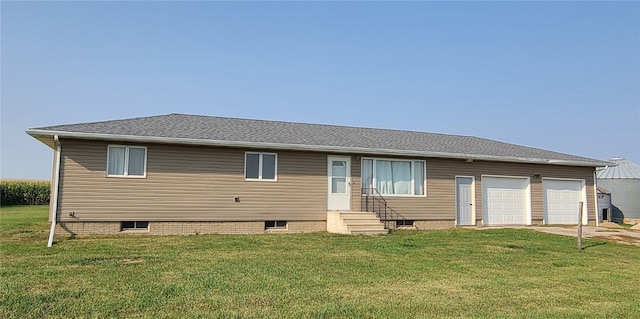 rear view of house featuring a garage and a yard