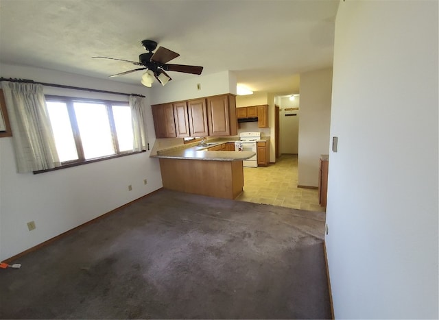 kitchen featuring kitchen peninsula, electric range, ceiling fan, sink, and light carpet