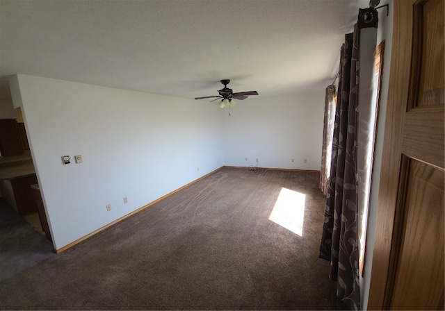 unfurnished living room featuring ceiling fan and dark carpet