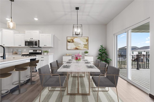 dining space with light hardwood / wood-style floors and sink