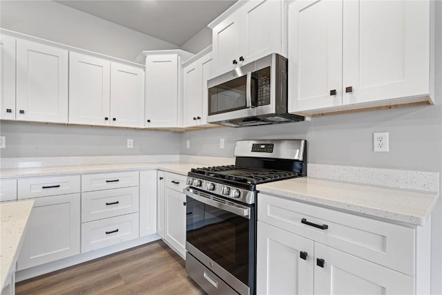 kitchen featuring white cabinetry, light hardwood / wood-style flooring, stainless steel appliances, and light stone counters