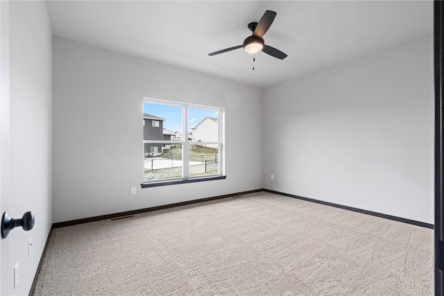 spare room with ceiling fan and light carpet