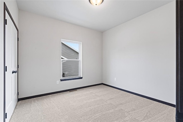 spare room featuring light colored carpet