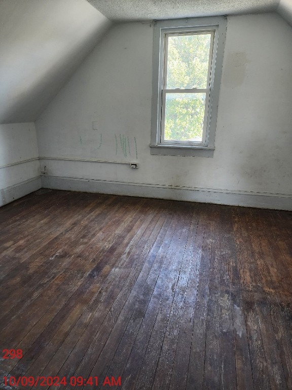 bonus room featuring lofted ceiling, a textured ceiling, and dark hardwood / wood-style floors