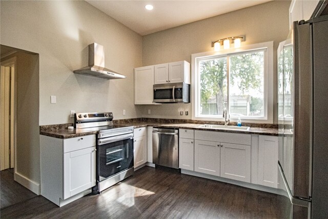 kitchen with wall chimney exhaust hood, stainless steel appliances, white cabinets, and dark hardwood / wood-style flooring