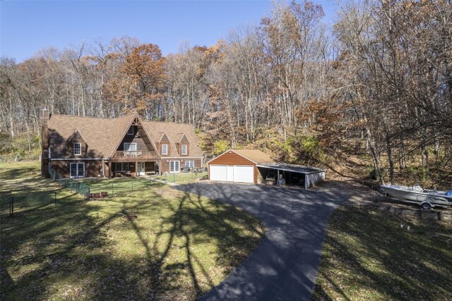 view of front of home featuring a garage, a front lawn, and an outdoor structure