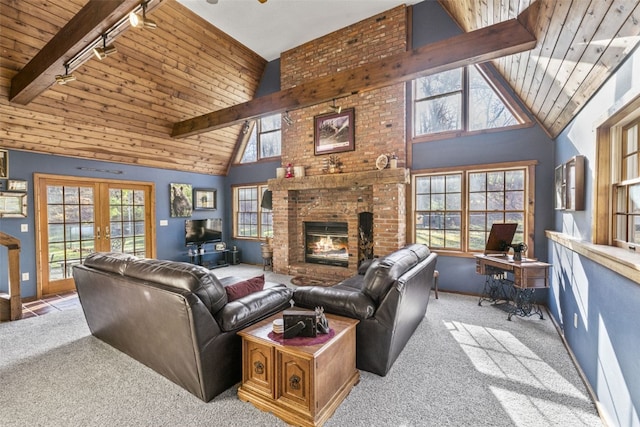 living room with beam ceiling, french doors, light colored carpet, and track lighting