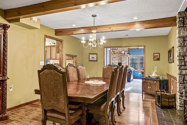 dining room with beam ceiling, wood-type flooring, a textured ceiling, and a notable chandelier