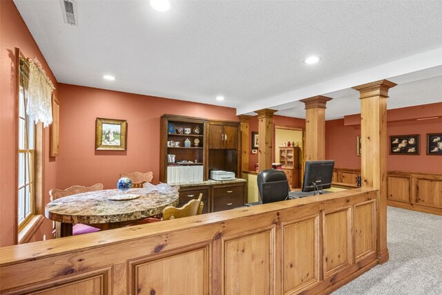 interior space featuring a textured ceiling and decorative columns