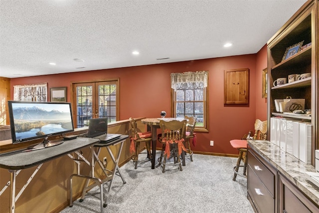 interior space with french doors, light colored carpet, and a textured ceiling