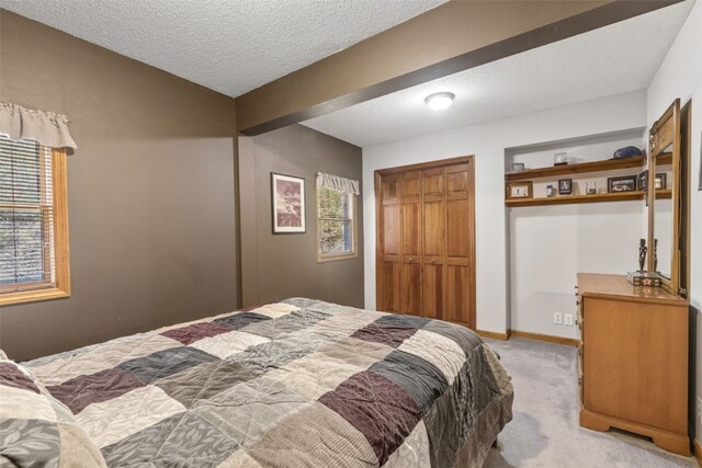 carpeted bedroom with a textured ceiling and a closet