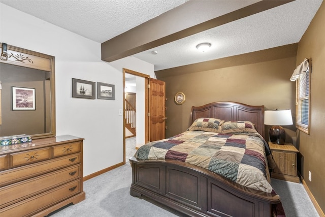 bedroom with light colored carpet and a textured ceiling