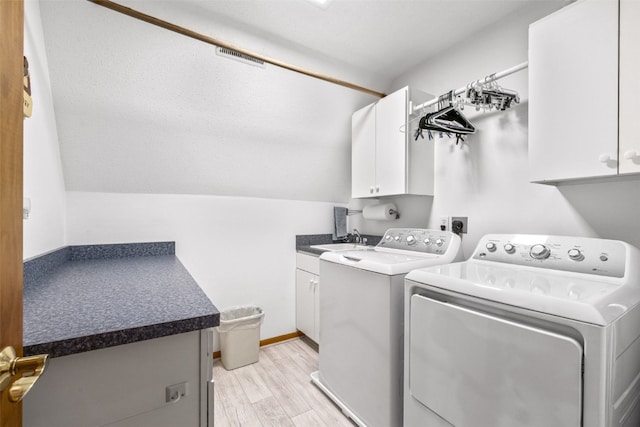 laundry room with cabinets, washing machine and dryer, light hardwood / wood-style flooring, and sink