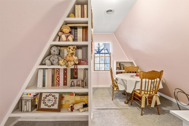 rec room featuring carpet, a textured ceiling, and vaulted ceiling