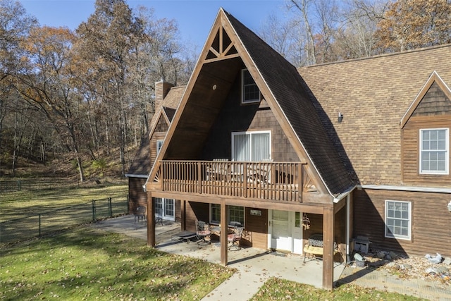 rear view of house with a patio area, a yard, and a wooden deck