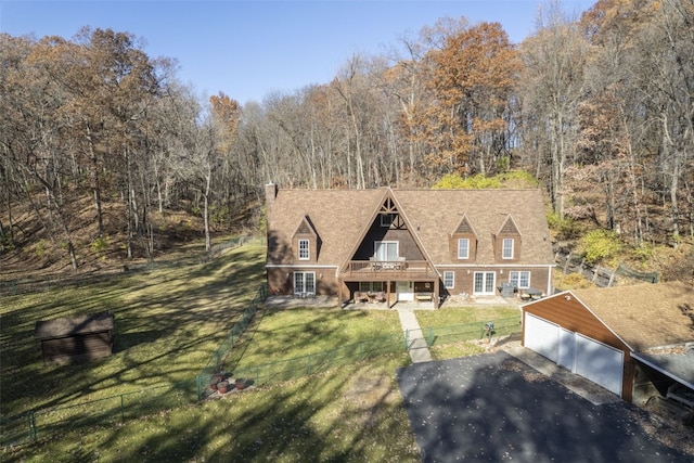 exterior space with a wooden deck, an outbuilding, a front yard, and a garage