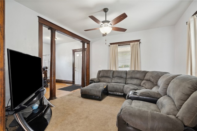 carpeted living room with decorative columns and ceiling fan