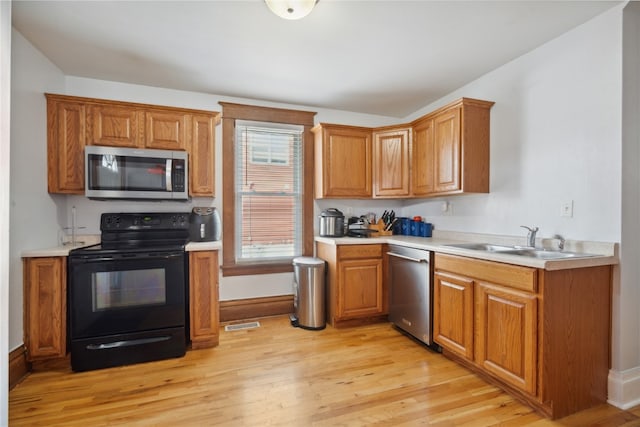 kitchen featuring light hardwood / wood-style floors, appliances with stainless steel finishes, and sink