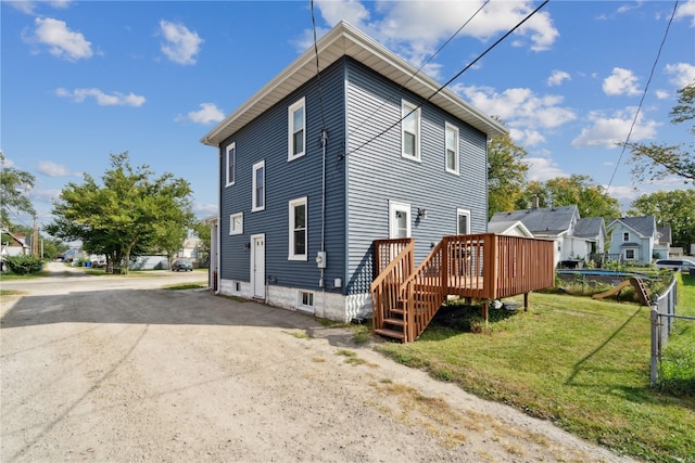 back of house with a yard and a wooden deck