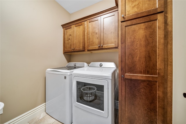 laundry area featuring cabinets, washing machine and clothes dryer, and light tile patterned floors