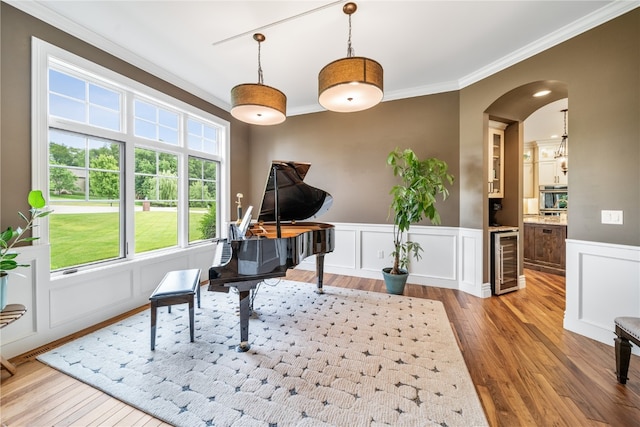 interior space featuring wine cooler, light hardwood / wood-style floors, and crown molding