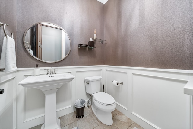 bathroom featuring sink, toilet, and tile patterned floors