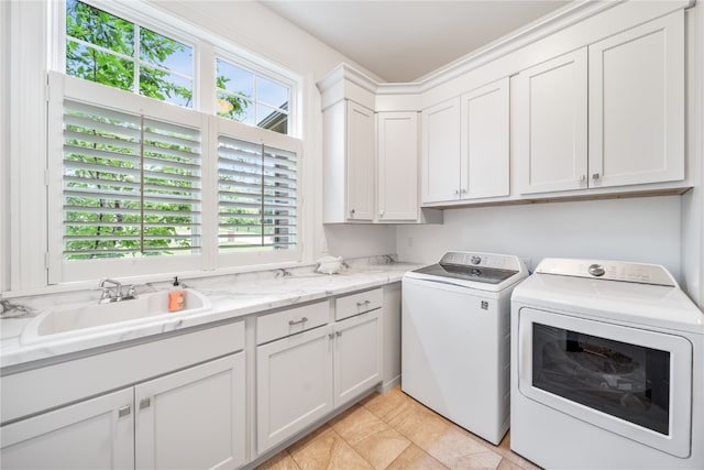 laundry room featuring washer and clothes dryer, sink, and cabinets