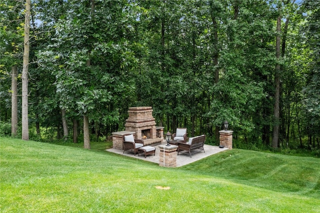 view of yard featuring a patio area and an outdoor stone fireplace