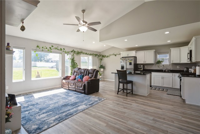 living room with light hardwood / wood-style floors, ceiling fan, and plenty of natural light