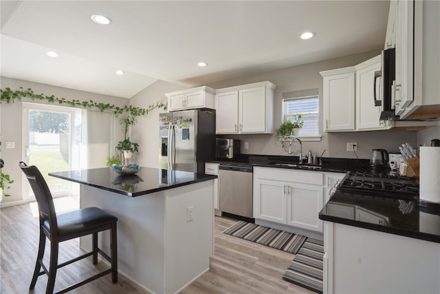 kitchen featuring light hardwood / wood-style floors, white cabinetry, stainless steel appliances, a center island, and sink