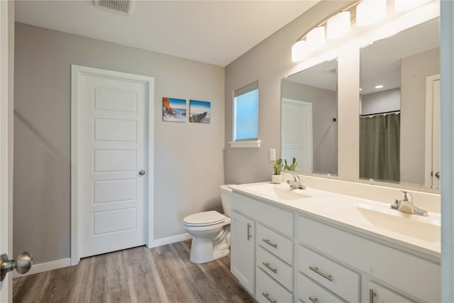 bathroom featuring a shower with curtain, vanity, hardwood / wood-style floors, and toilet