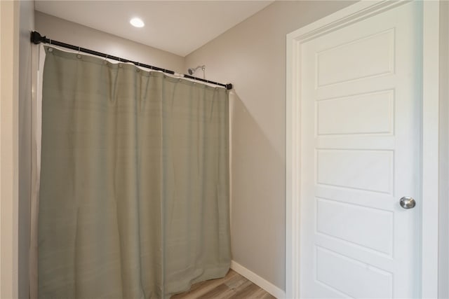 bathroom with hardwood / wood-style floors and a shower with shower curtain