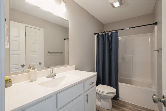 full bathroom with shower / bath combo with shower curtain, wood-type flooring, vanity, and toilet