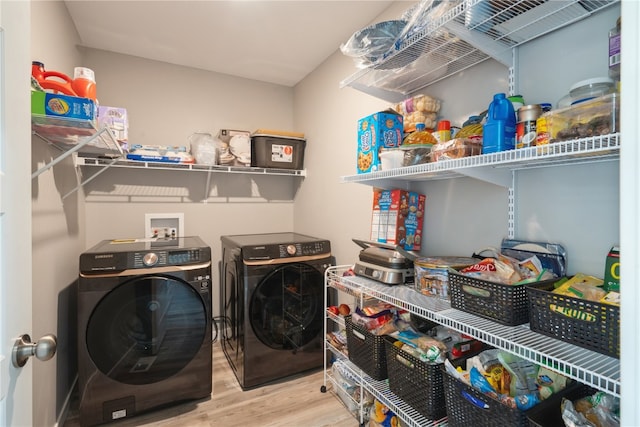 washroom with light hardwood / wood-style flooring and washing machine and clothes dryer