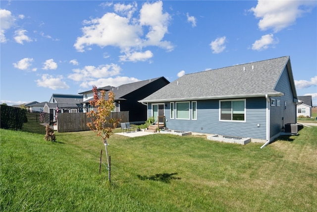 rear view of property featuring central AC unit, a lawn, and a patio area