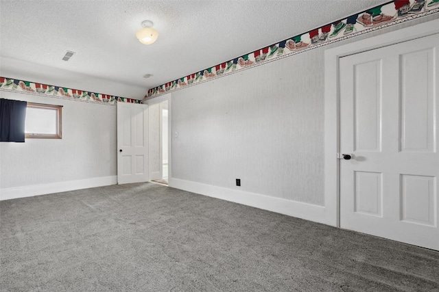 empty room with a textured ceiling and carpet flooring