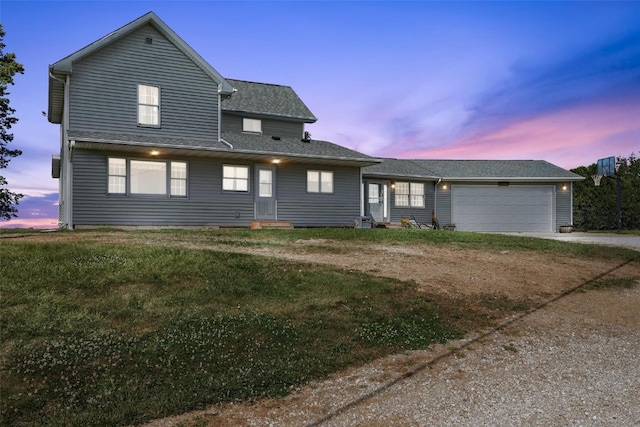 view of front of home with a garage and a yard