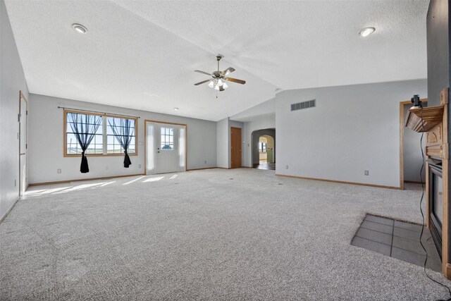 unfurnished living room featuring a textured ceiling, lofted ceiling, ceiling fan, and light colored carpet