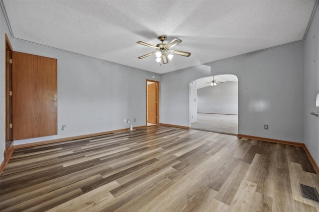 empty room featuring ceiling fan, a textured ceiling, and wood-type flooring