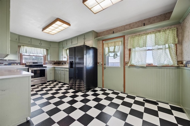 kitchen with green cabinetry, black fridge with ice dispenser, and stainless steel electric stove