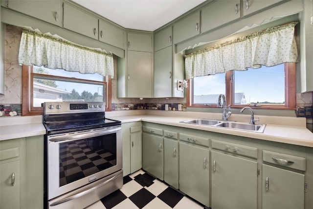 kitchen with backsplash, sink, stainless steel range with electric cooktop, and a wealth of natural light