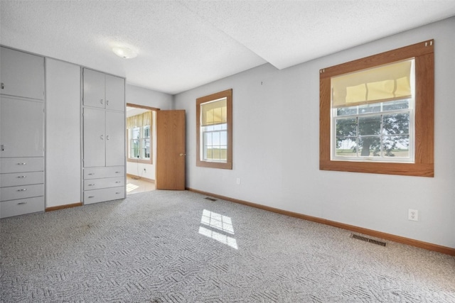 unfurnished bedroom featuring light colored carpet and a textured ceiling