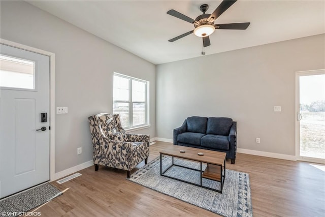 living area featuring light hardwood / wood-style floors and ceiling fan