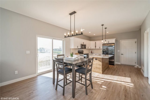 dining space featuring light hardwood / wood-style flooring and sink