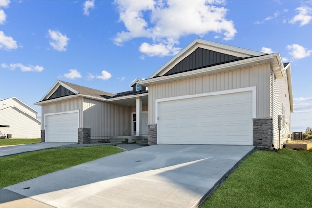 view of front of home featuring a front lawn, central AC unit, and a garage