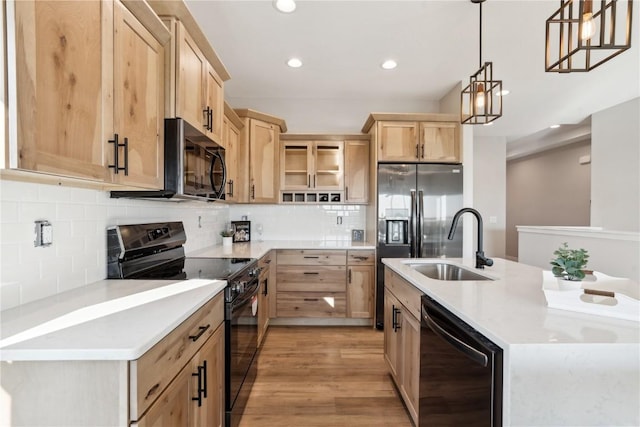 kitchen featuring sink, decorative backsplash, hanging light fixtures, black appliances, and light brown cabinets