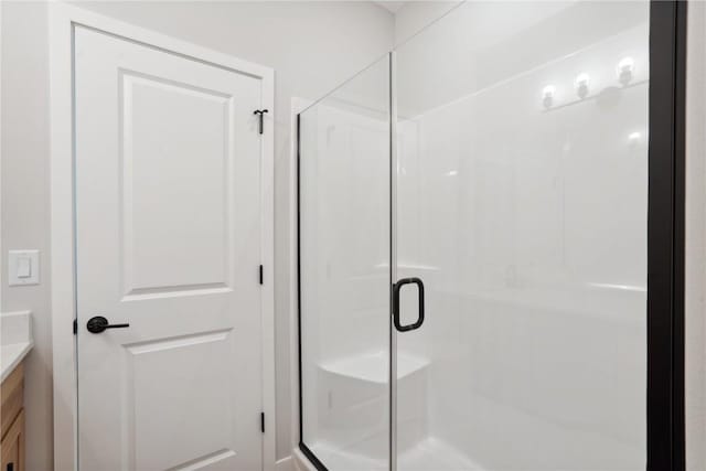 bathroom with vanity and a shower with shower door