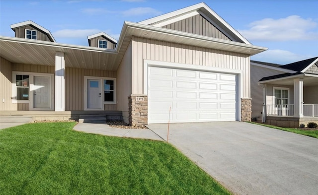 view of front of property with a garage, covered porch, and a front lawn